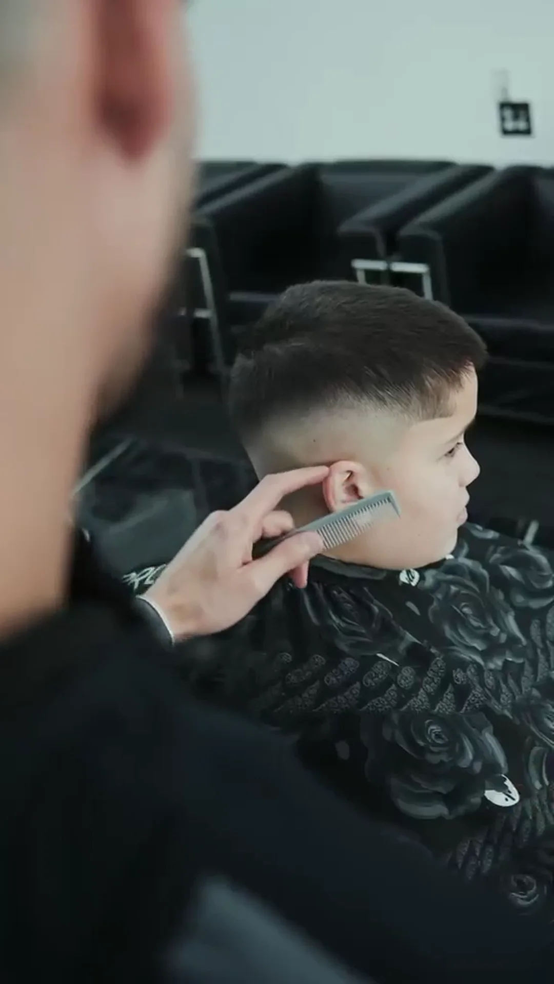 A boy having his hair combed and cut